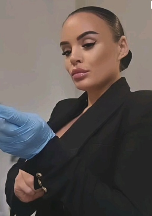 Chloe performing a cosmetic treatment, wearing a black blazer and blue nitrile gloves